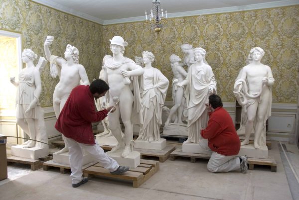 Restauración de esculturas clásicas en taller especializado, preservando el arte y la historia en un entorno elegante y artístico.